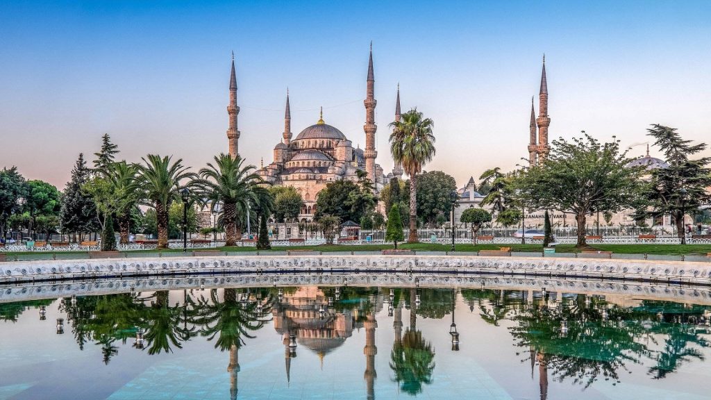 Sultan Ahmed Mosque Blue Mosque with six minarets reflected in fountain framed by palm trees Wallpaper