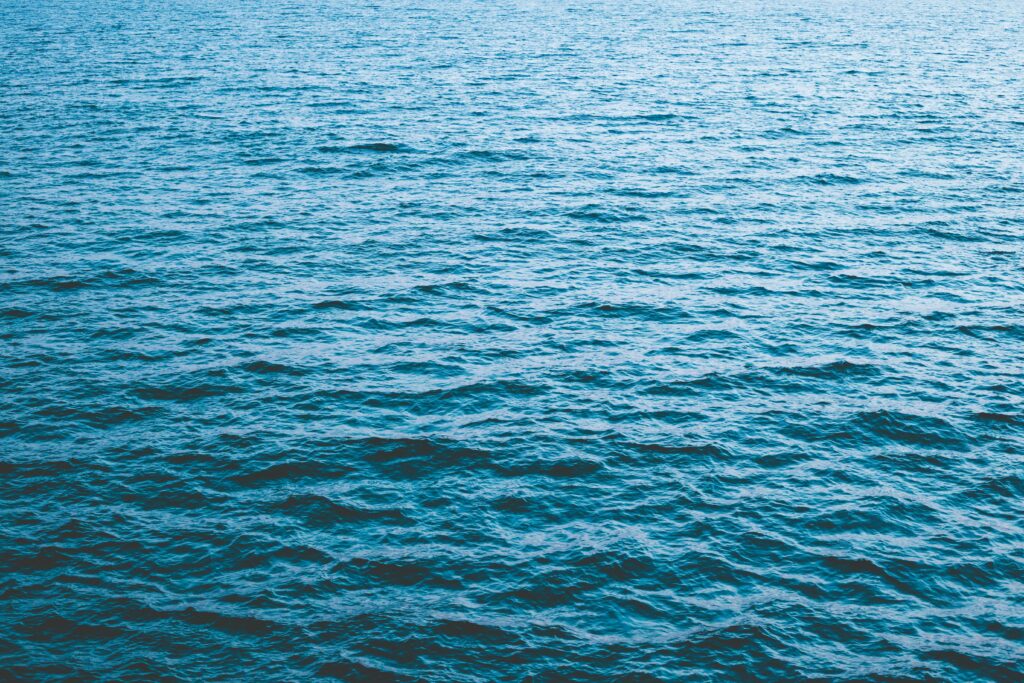 Serene vibrant blue ocean wallpaper with gentle ripples and calm minimalist high-resolution background