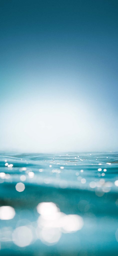 Close-up sparkling turquoise ocean water with sunlight reflections minimalist phone wallpaper background