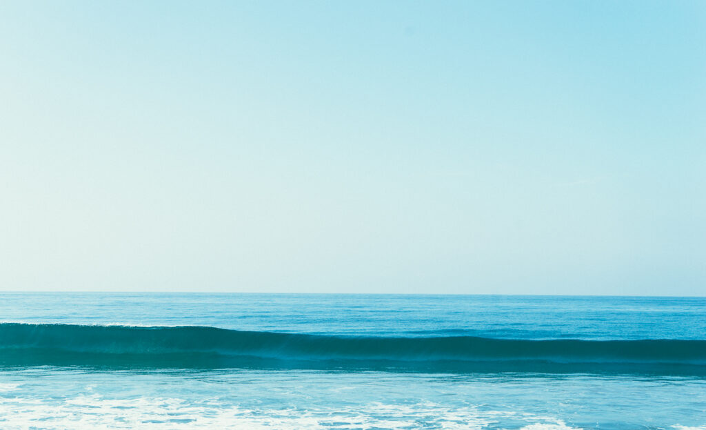 Tranquil blue seascape wallpaper with gentle waves and clear sky for calm minimalist background