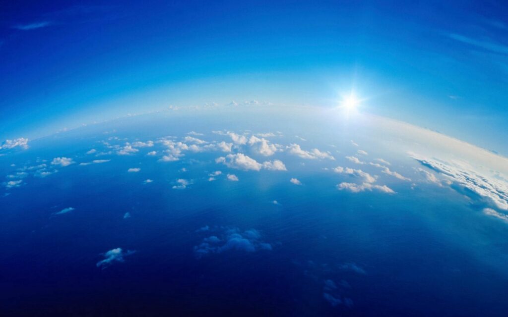 Breathtaking aerial view of blue sky white clouds and radiant sun creating serene wallpaper background