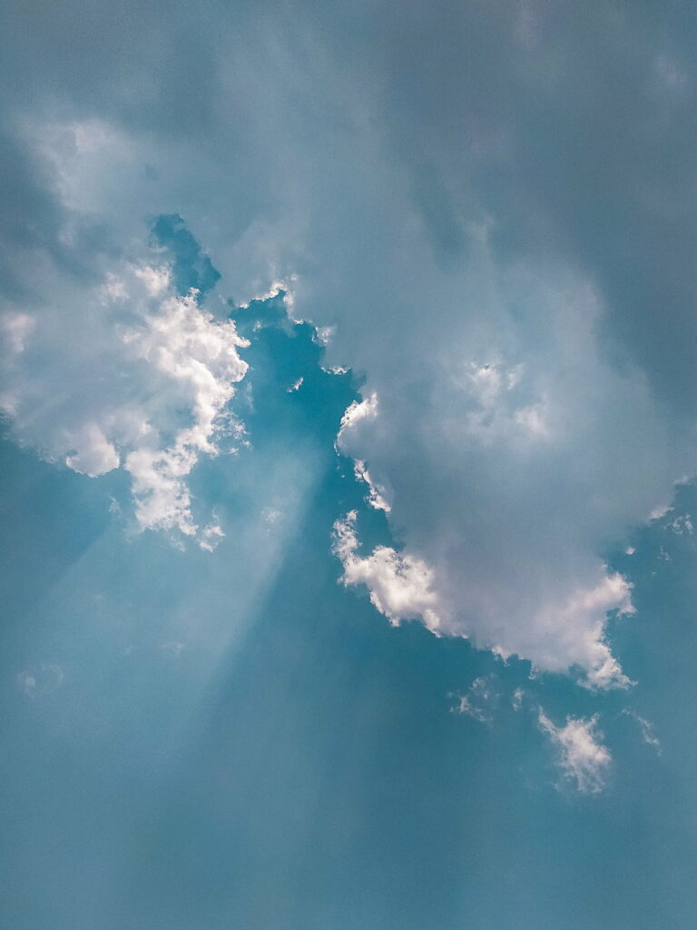 Serene Blue Sky HD Wallpaper with Fluffy Clouds and Sun Rays