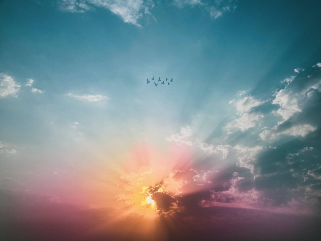 Serene blue sky with birds sunset wallpaper glowing orange pink clouds and radiant light rays