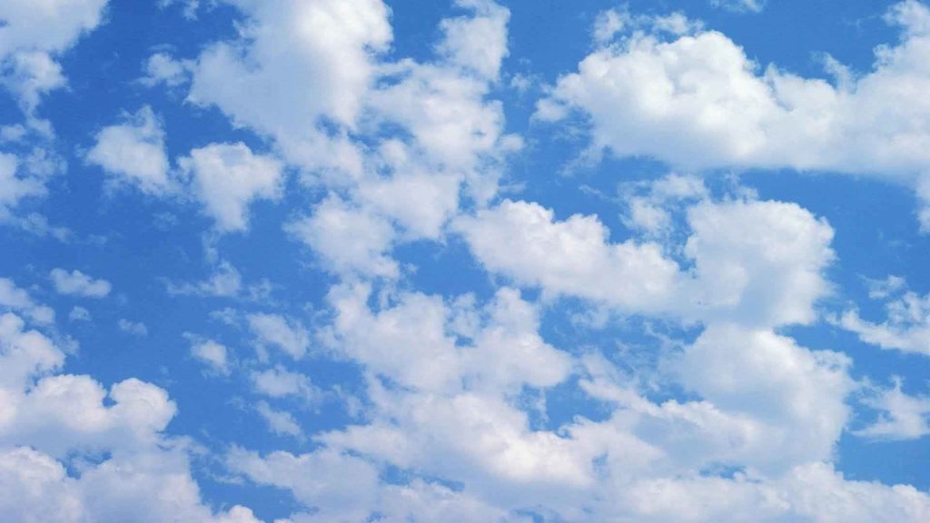 Vibrant blue sky with soft white clouds on a clear bright day serene nature wallpaper background