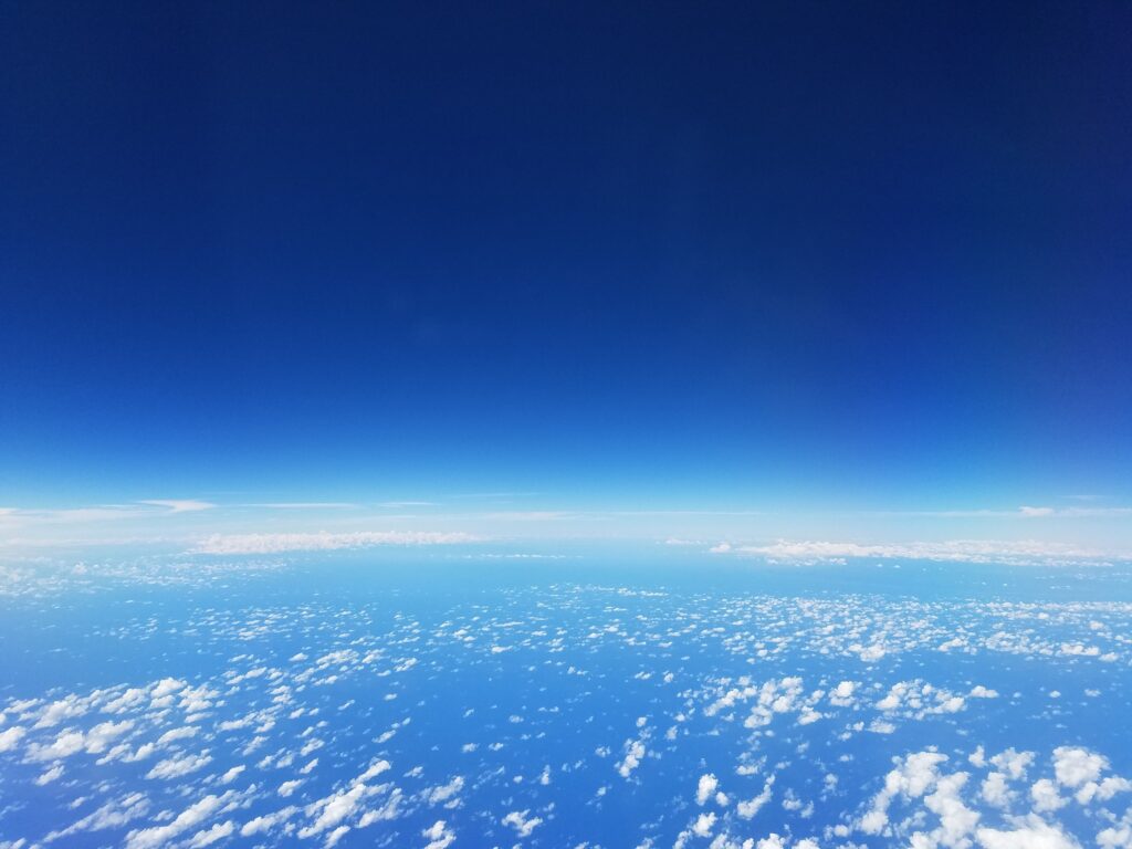 Serene blue sky wallpaper with soft scattered clouds and smooth gradient for tranquil background