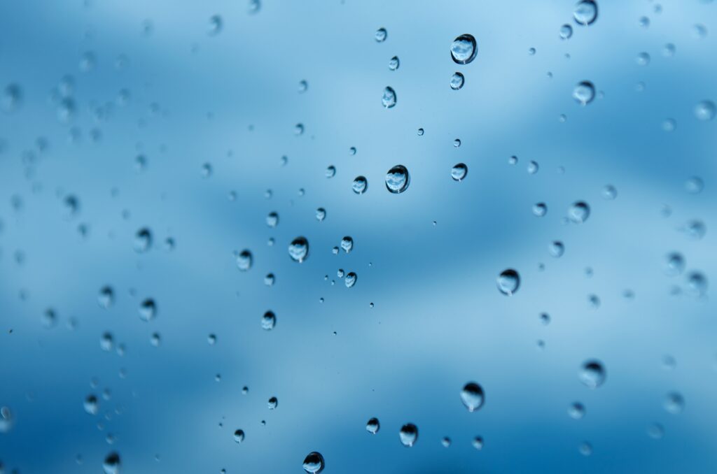 Calming Macro Wallpaper: Water Droplets on Glass with Blue Background