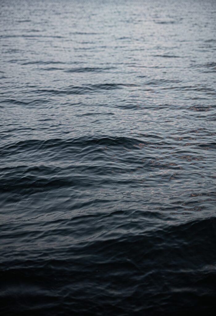 Close-up of serene water surface with gentle ripples blue gray tones natural texture wallpaper