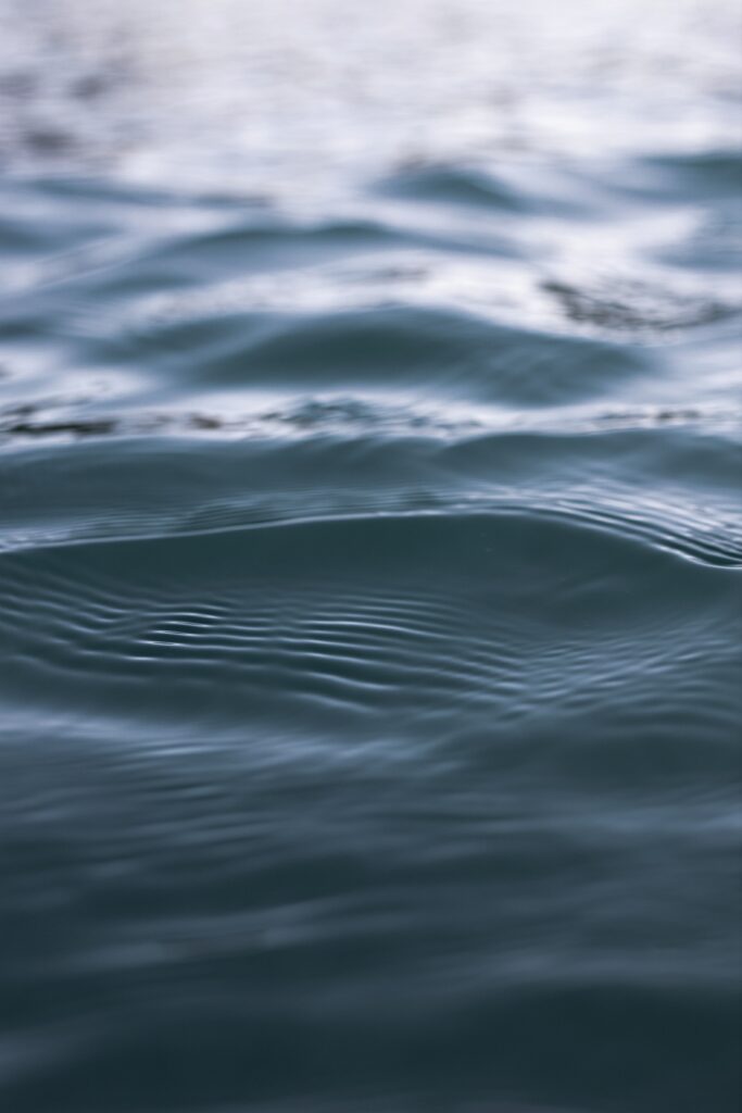 Calm water surface wallpaper with soft ripples gentle glare and blue gradients reflecting light