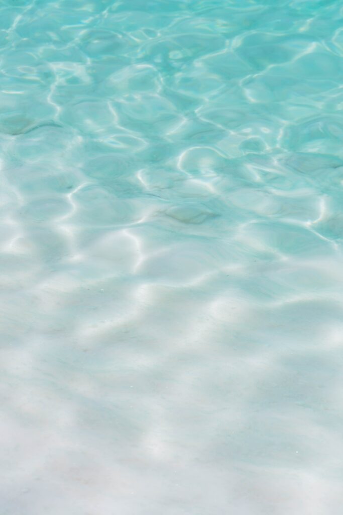Serene blue water wallpaper with gentle waves ripples and soft light reflections for calm background