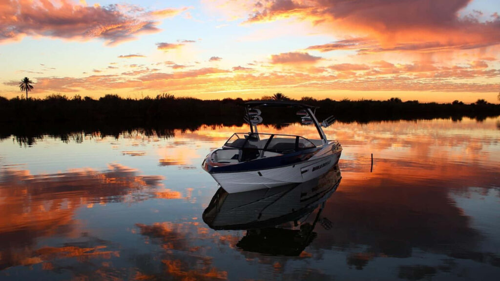 Serene Boat on Calm Waters at Sunset - Tranquil Wallpaper Background