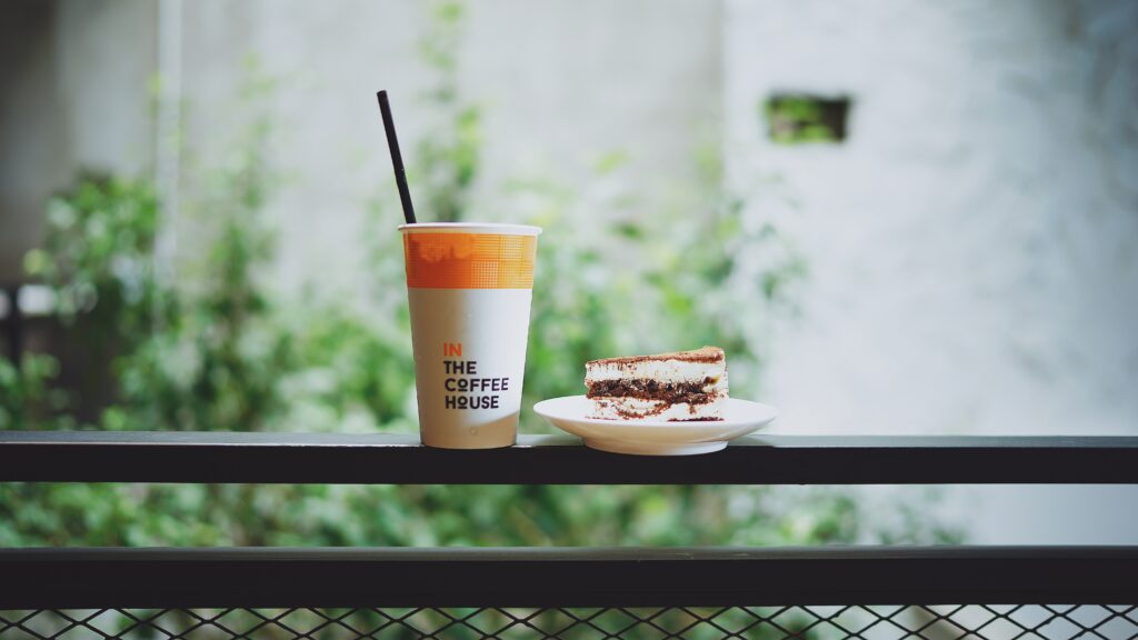 Serene Breakfast Wallpaper: Cake & Coffee with Greenery Background