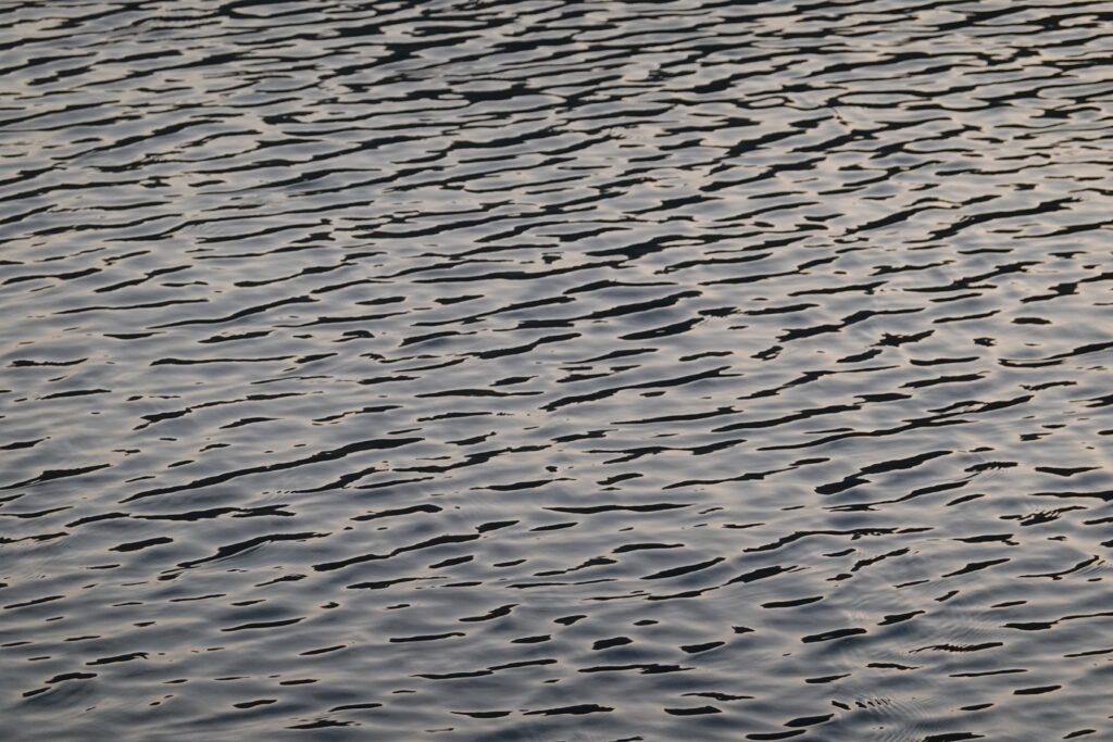 Calm water wallpaper with gentle ripples and soft gray blue waves for a serene background