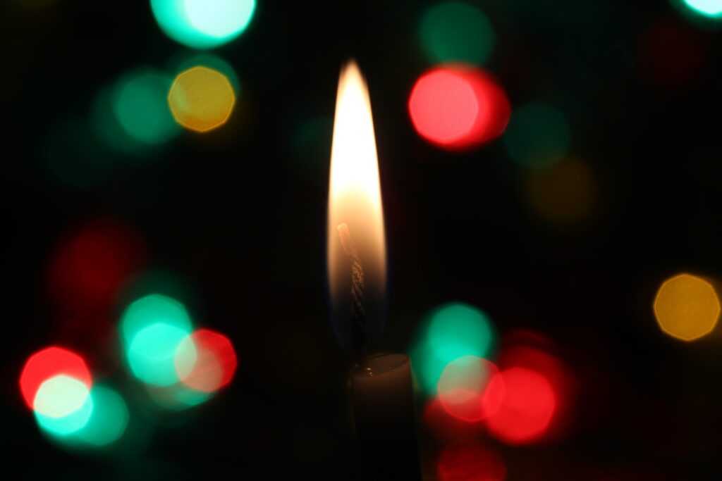 Serene Candle Flame Wallpaper with Colorful Bokeh Lights