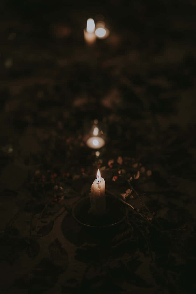 Tranquil Candlelit Wallpaper: Serenity Amidst Dark Foliage