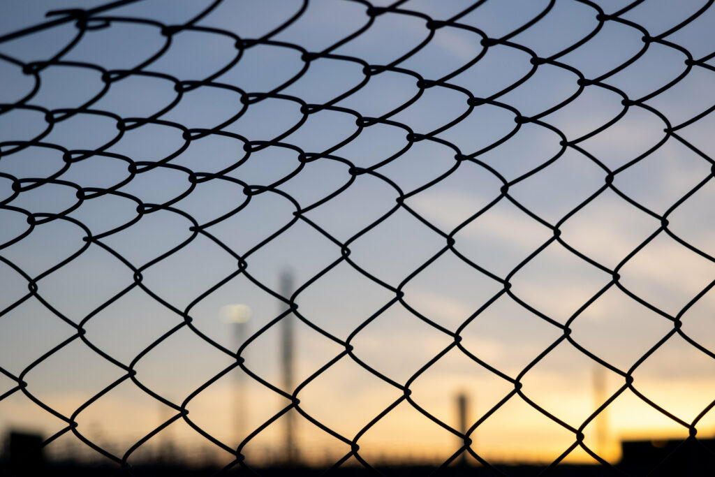 Chain-Link Fence Close-Up with Sunset Sky - Wallpaper Background