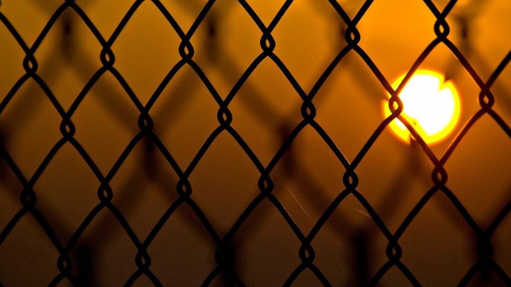 Serene Chain-Link Fence Wallpaper with Sunset Glow Background