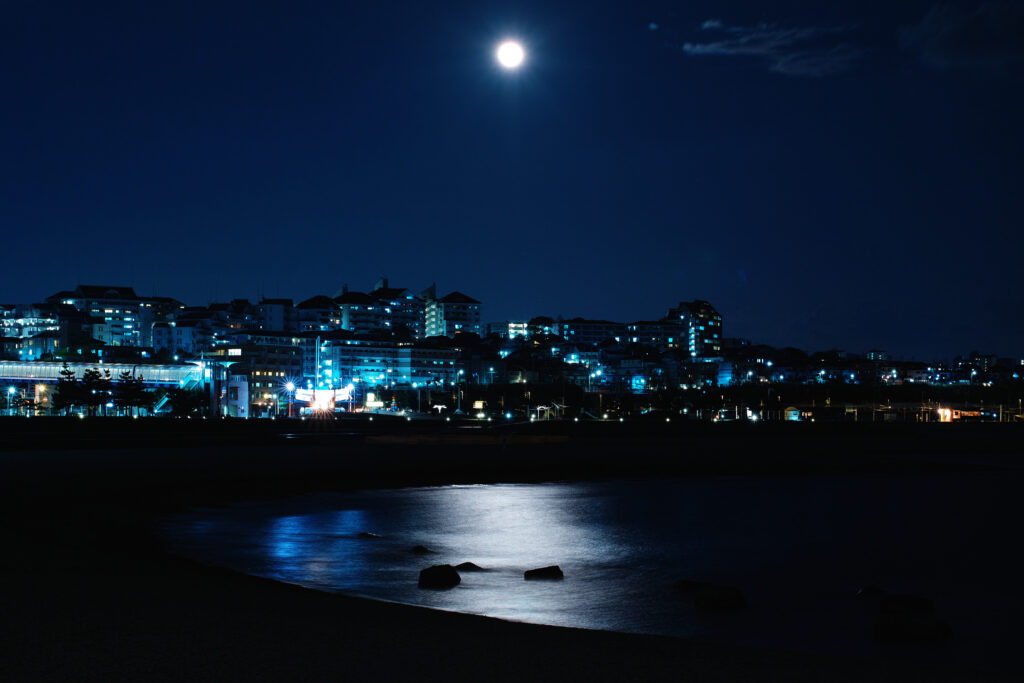 Serene City by the Sea: Moonlit Night Wallpaper Background