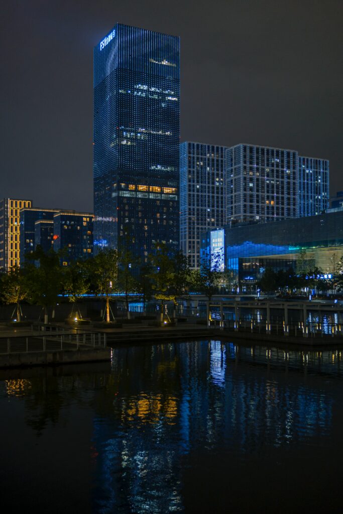Serene Night Cityscape Wallpaper: Illuminated Buildings & Calm Water