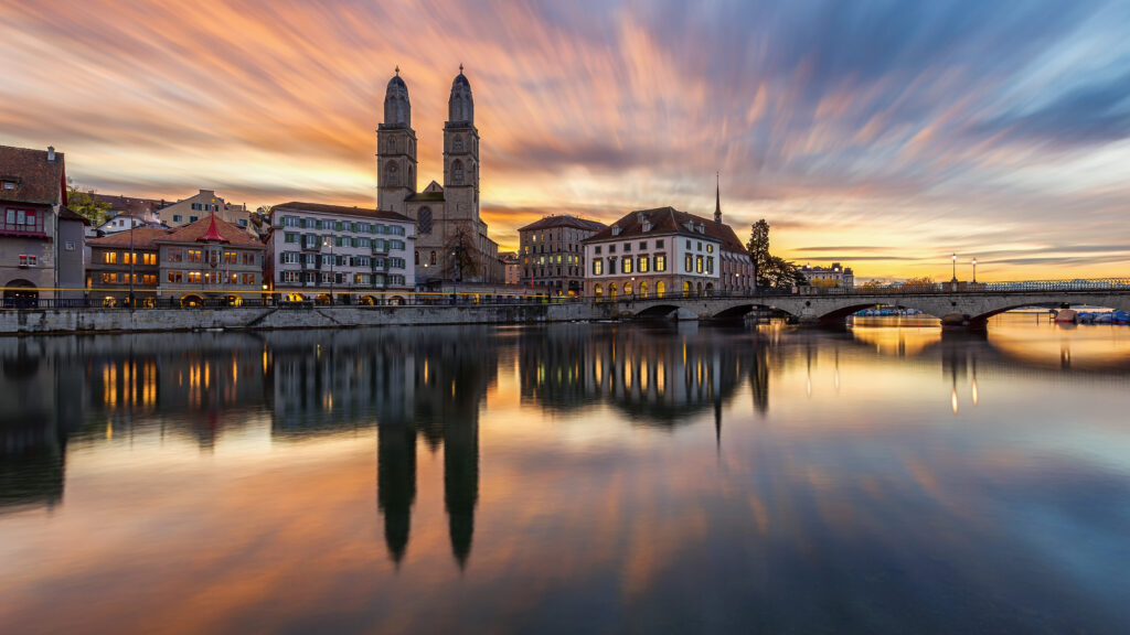 Serene Sunset Cityscape Wallpaper: Tower, Chapel & Calm Waters