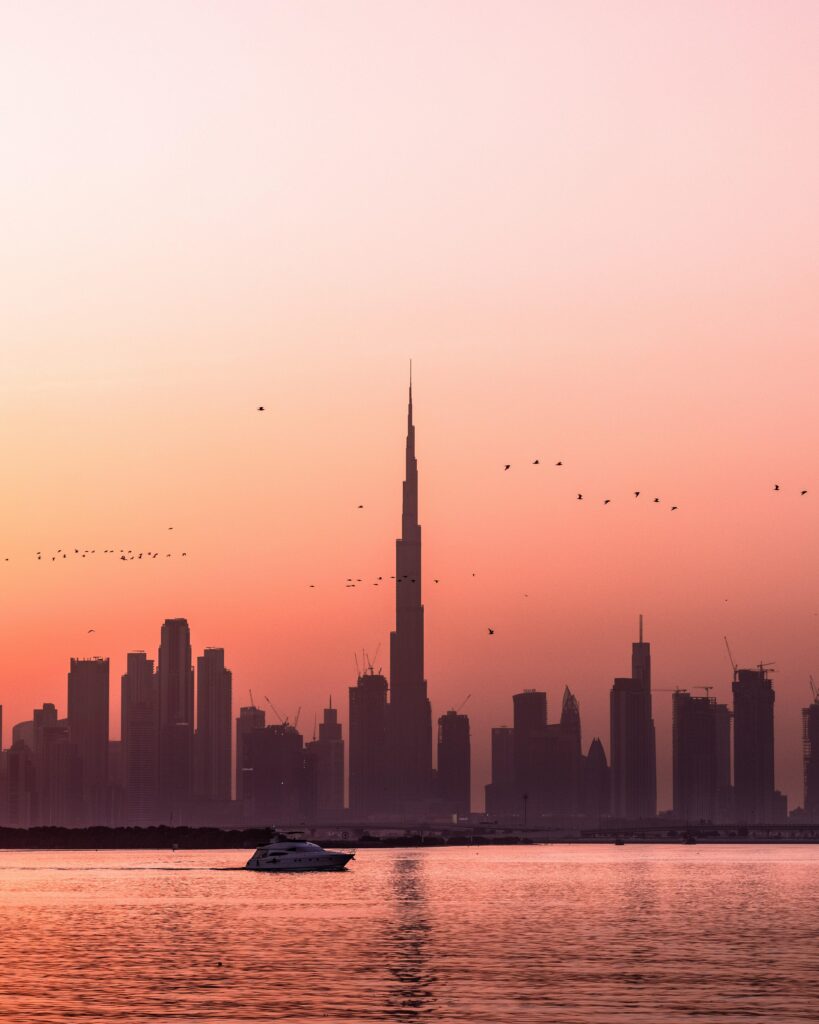Serene Sunset Cityscape Wallpaper: Tranquil Water & Vibrant Skies