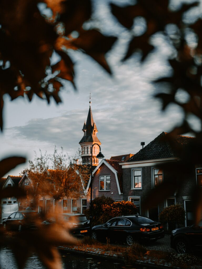 Serene Cityscape Wallpaper: Dusk Glow with Classic Architecture & Foliage