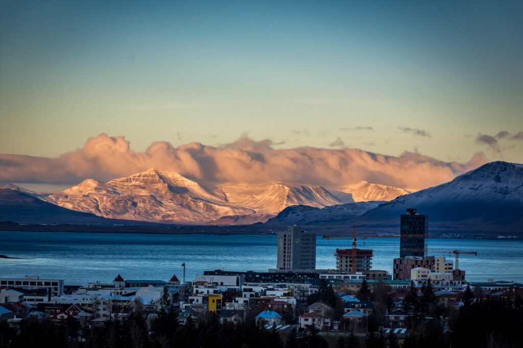 Serene Riverside Cityscape Wallpaper: Nature & Mountains Unite