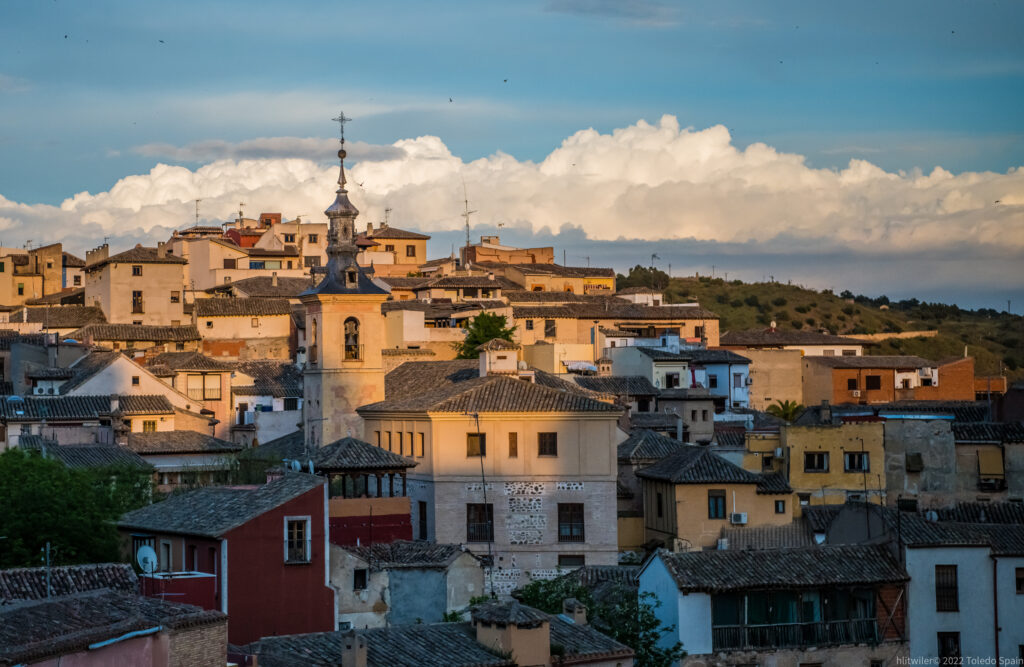 Serene Cityscape Wallpaper: Rustic Bell Tower & Lush Green Hillside