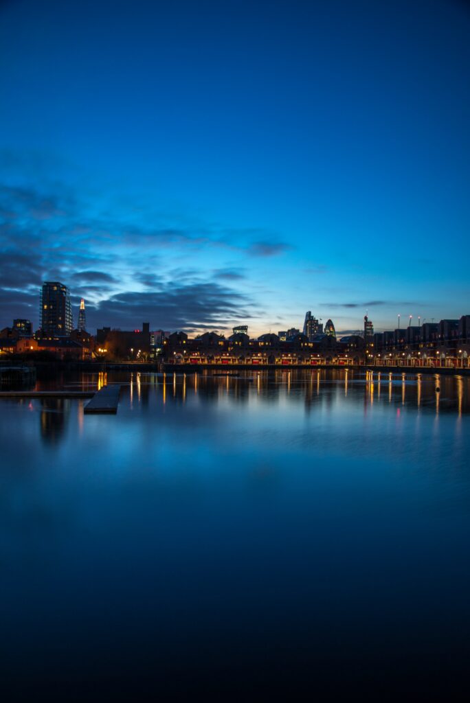 Serene Cityscape Wallpaper: Skyscrapers Reflecting on Calm Waters