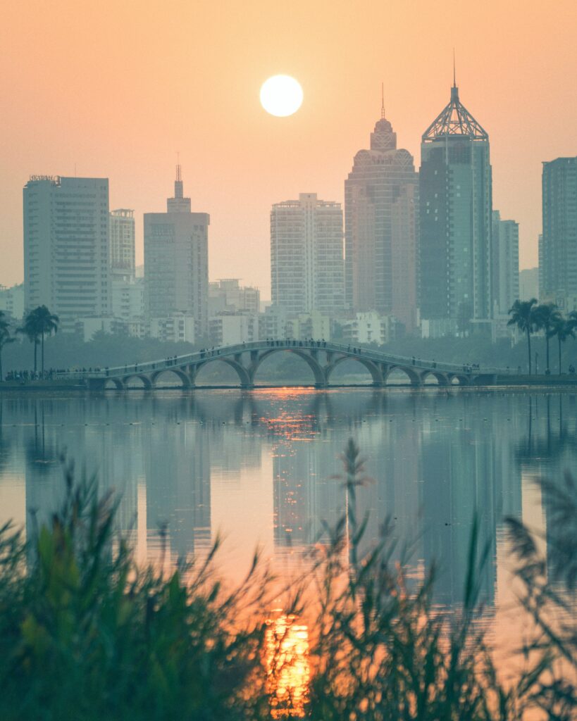 Peaceful Sunset Cityscape Wallpaper with Lake & Arched Bridge