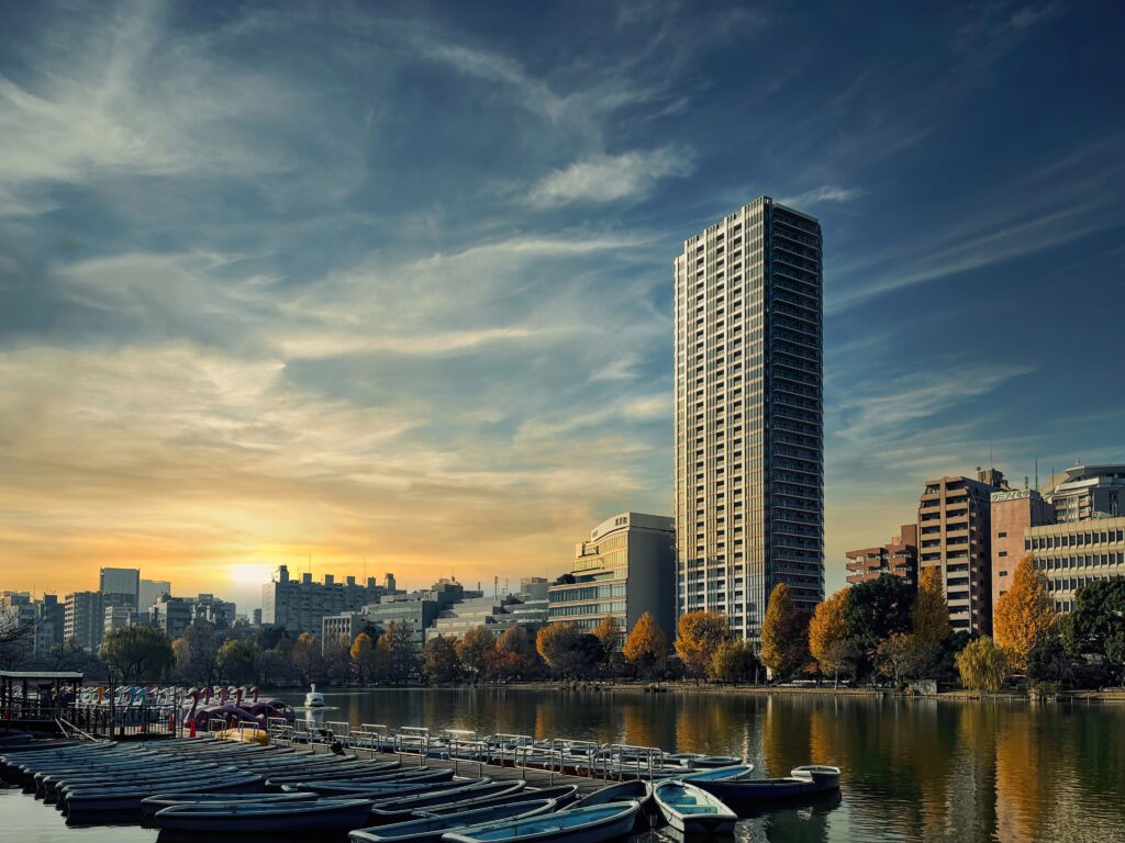 Serene Cityscape Wallpaper: Tranquil River & Sunset Autumn Hues