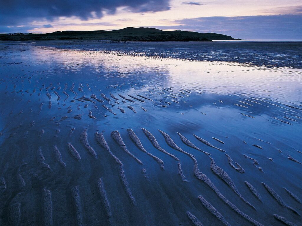 Serene coastal wallpaper with sand ripples tidal outflow twilight sky blue purple tranquil shore