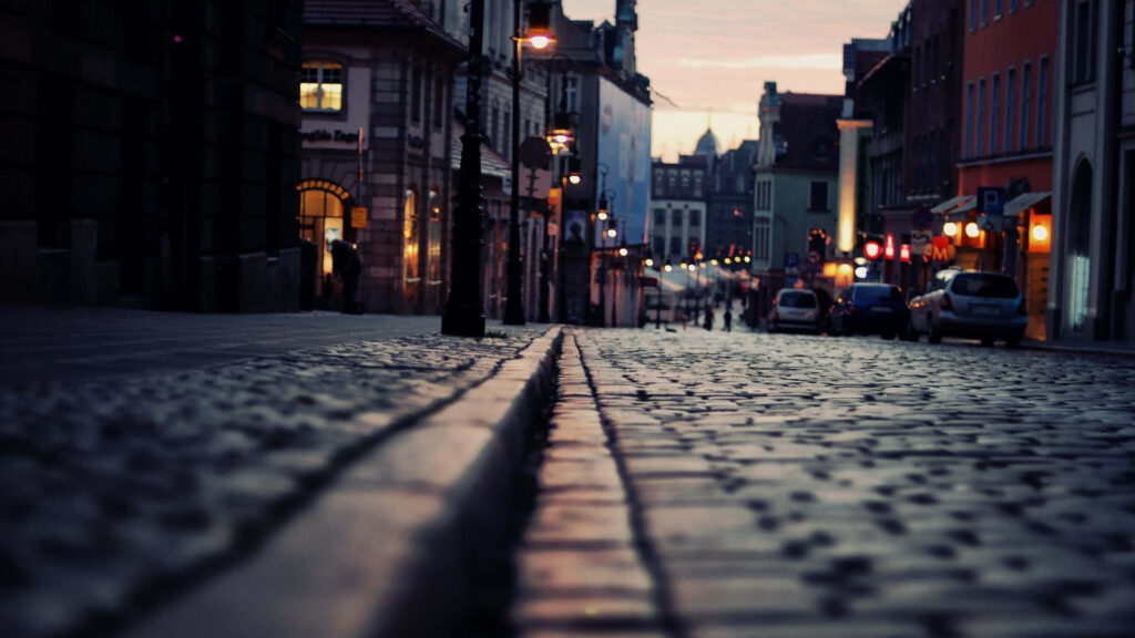 Serene Cobblestone Street at Dusk: Warm Lights & Nostalgic Architecture Wallpaper
