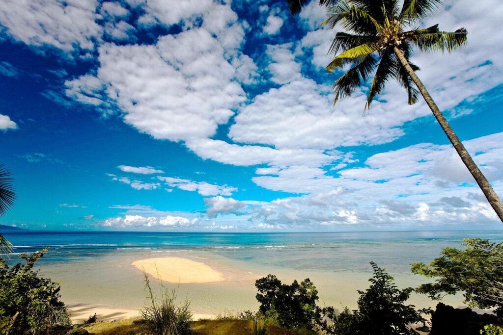 Stunning Comoros Beach Wallpaper: Turquoise Waters & Cloudy Skies