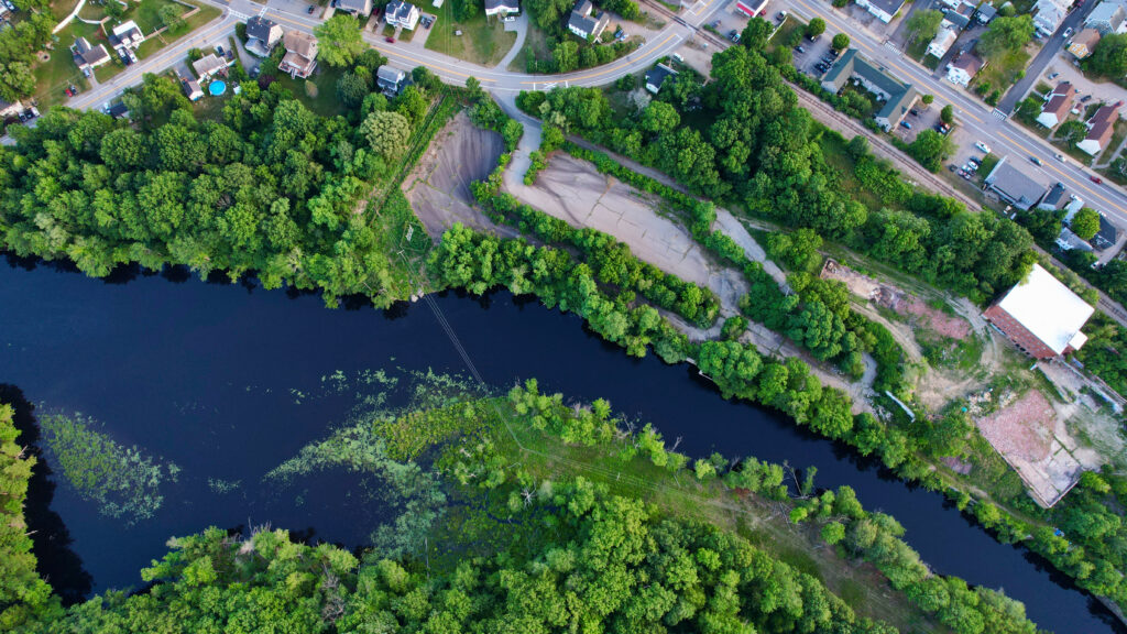 Aerial view of peaceful village with cozy houses river and lush green trees countryside wallpaper