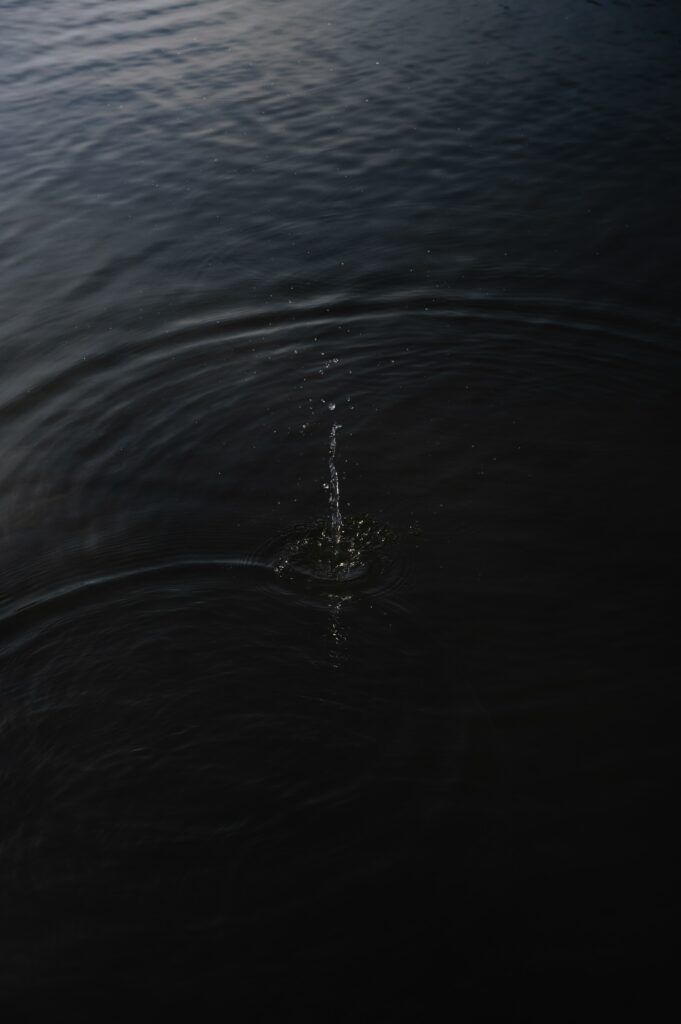 Serene Dark Water Wallpaper Background with Gentle Ripples & Droplets