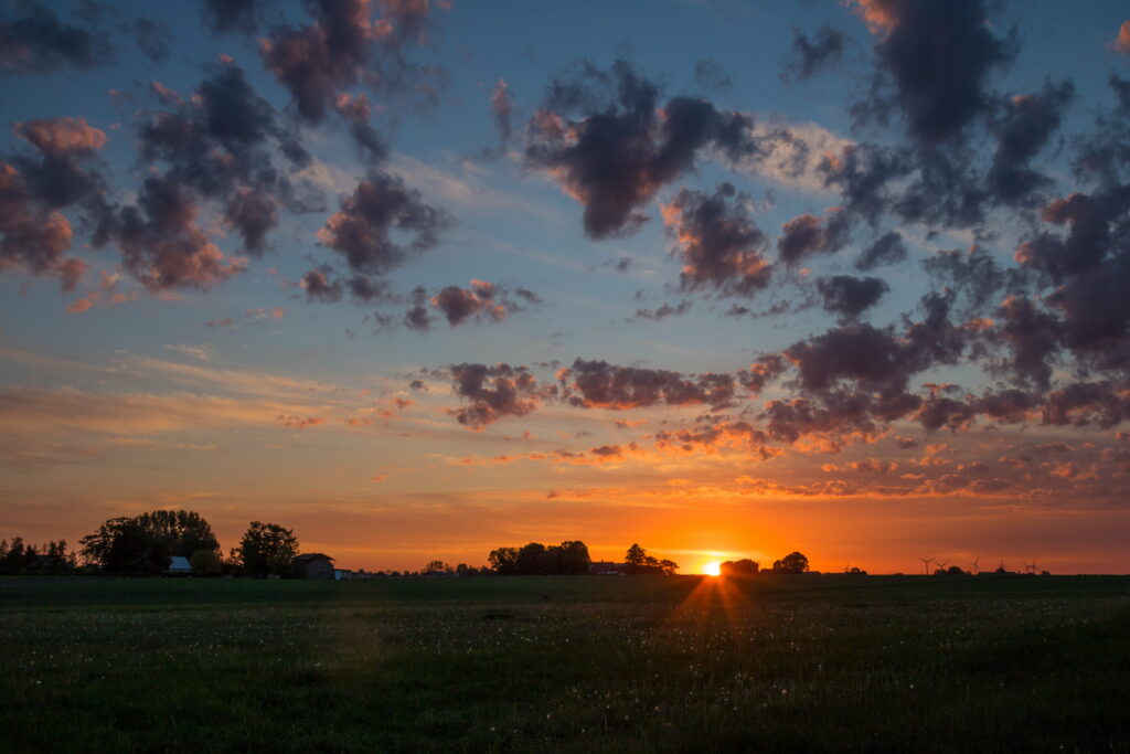 Serene Dawn Over Field: HD Sunrise Wallpaper with Warm Hues