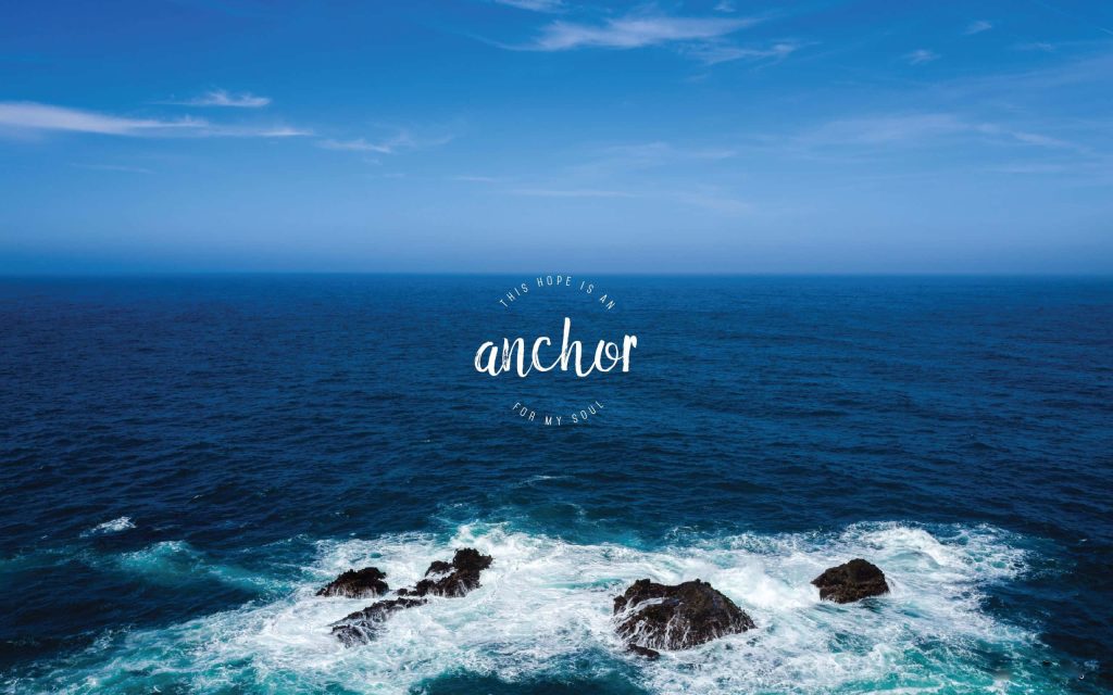Serene deep blue ocean waves crash over dark rocks with hope anchor quote laptop wallpaper background