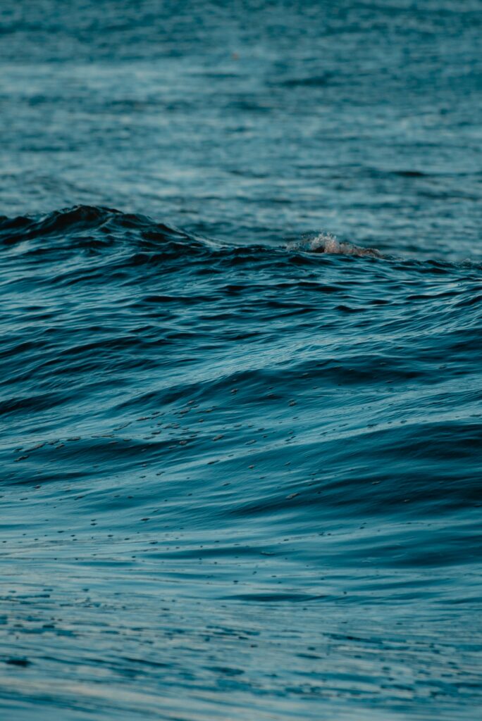 Realistic deep blue ocean waves with natural ripples creating a calm serene water texture background Wallpaper