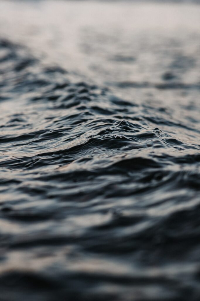 Close-up of calming sea water ripples with deep blue tones soft natural waves wallpaper background