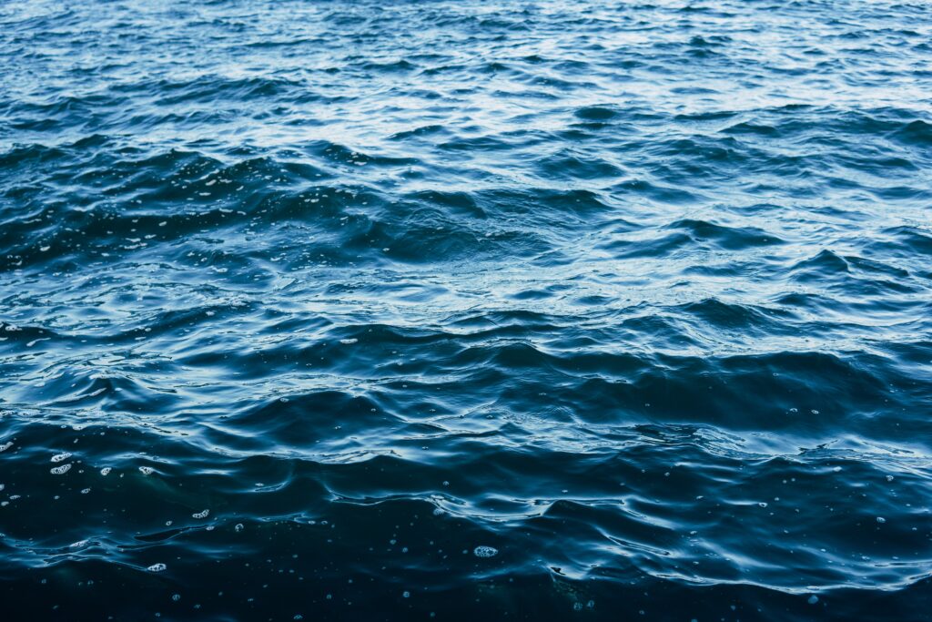 Calm sea wallpaper with gentle rippling deep blue waves creating a tranquil natural texture background