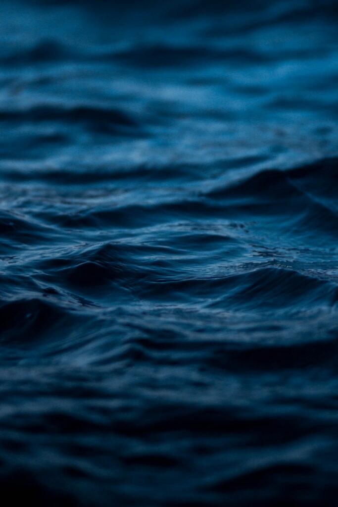 Close-up of deep blue water with gentle ripples and waves creating a serene sea background Wallpaper