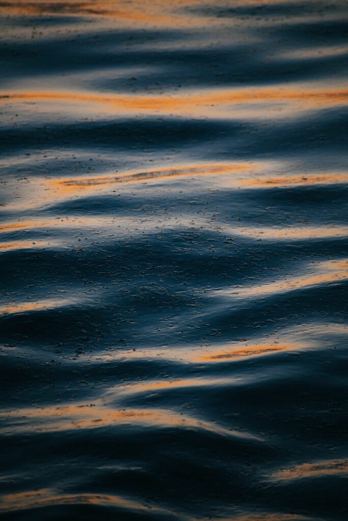 Calming water wallpaper with gentle blue waves and golden light reflections for serene background