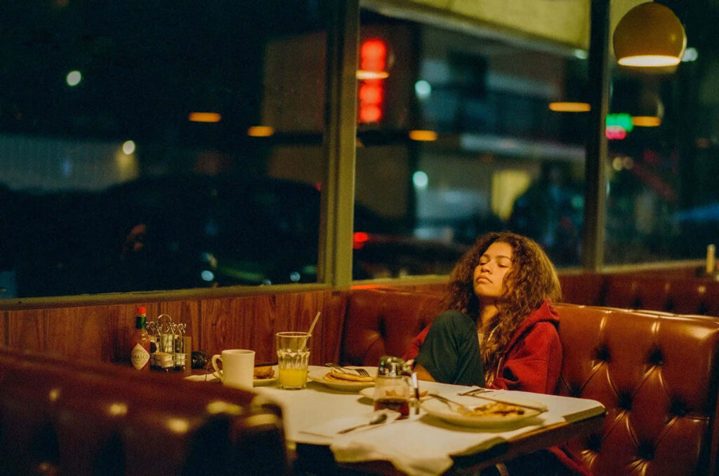 Serene Diner Scene: Solo Reflection in Warm Night Lighting Wallpaper