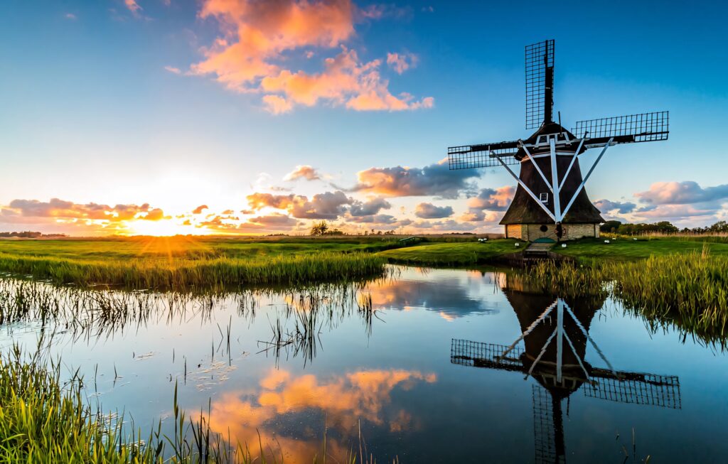 Serene Netherlands Windmill at Sunset - Reflective Water Wallpaper