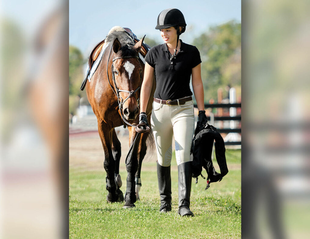 Serene Equestrian Bond: Female Rider Walking with Horse Wallpaper