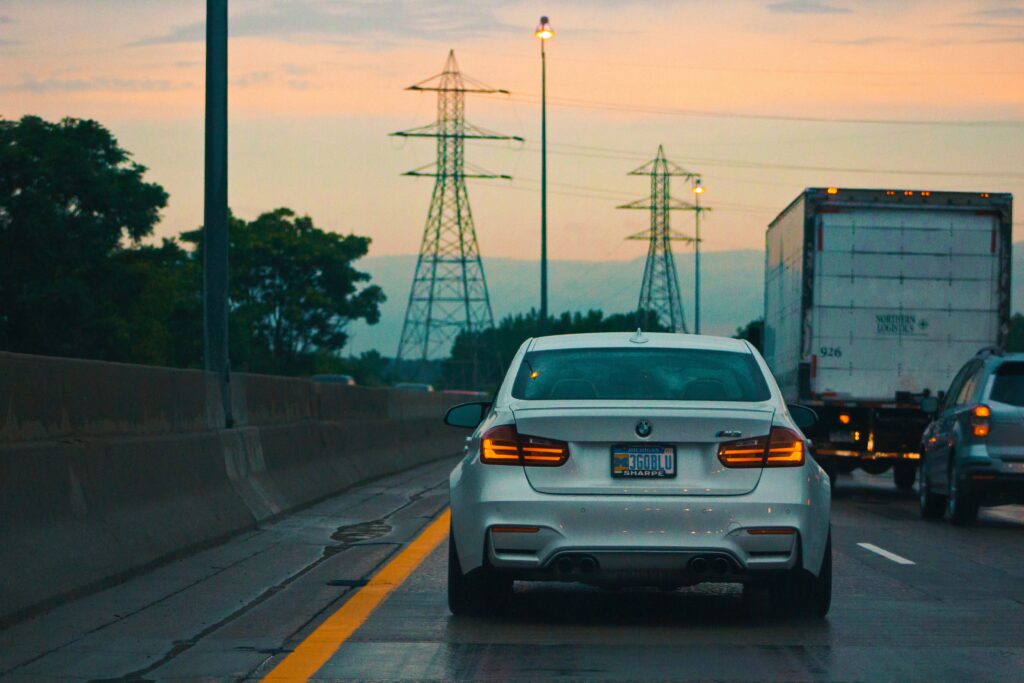 Serene Evening Drive: Traffic Glow with Sunset Background Wallpaper