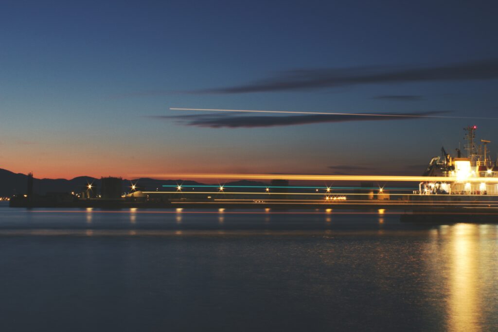 Serene Twilight Sea Wallpaper: Lit Pier & Gentle Reflections