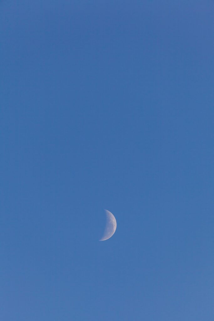 Serene crescent moon evening sky wallpaper with rich blue dusk and soft natural light background