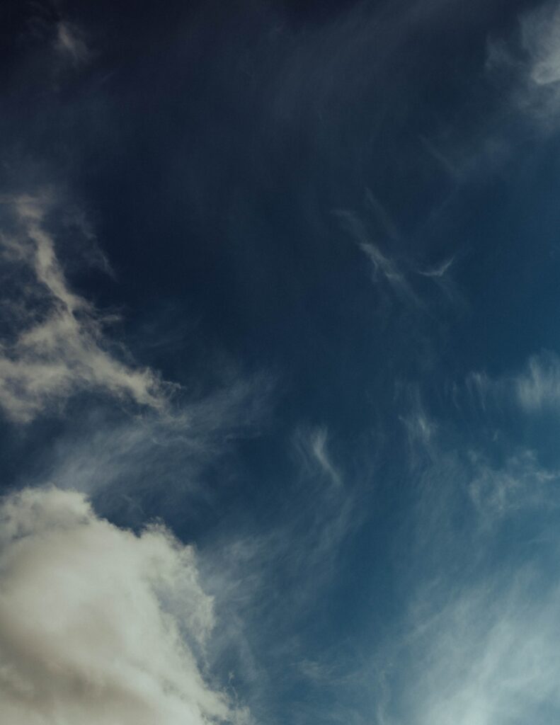 Serene evening sky wallpaper with soft wispy clouds and deep blue tranquil background