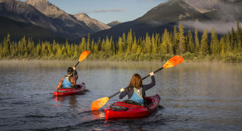 Serene Kayaking Wallpaper: Family Fun on a Calm Lake & Lush Mountains